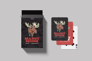 Mangy Moose playing cards - a black card box with the Mangy Moose logo on the front next to a stack of three playing cards